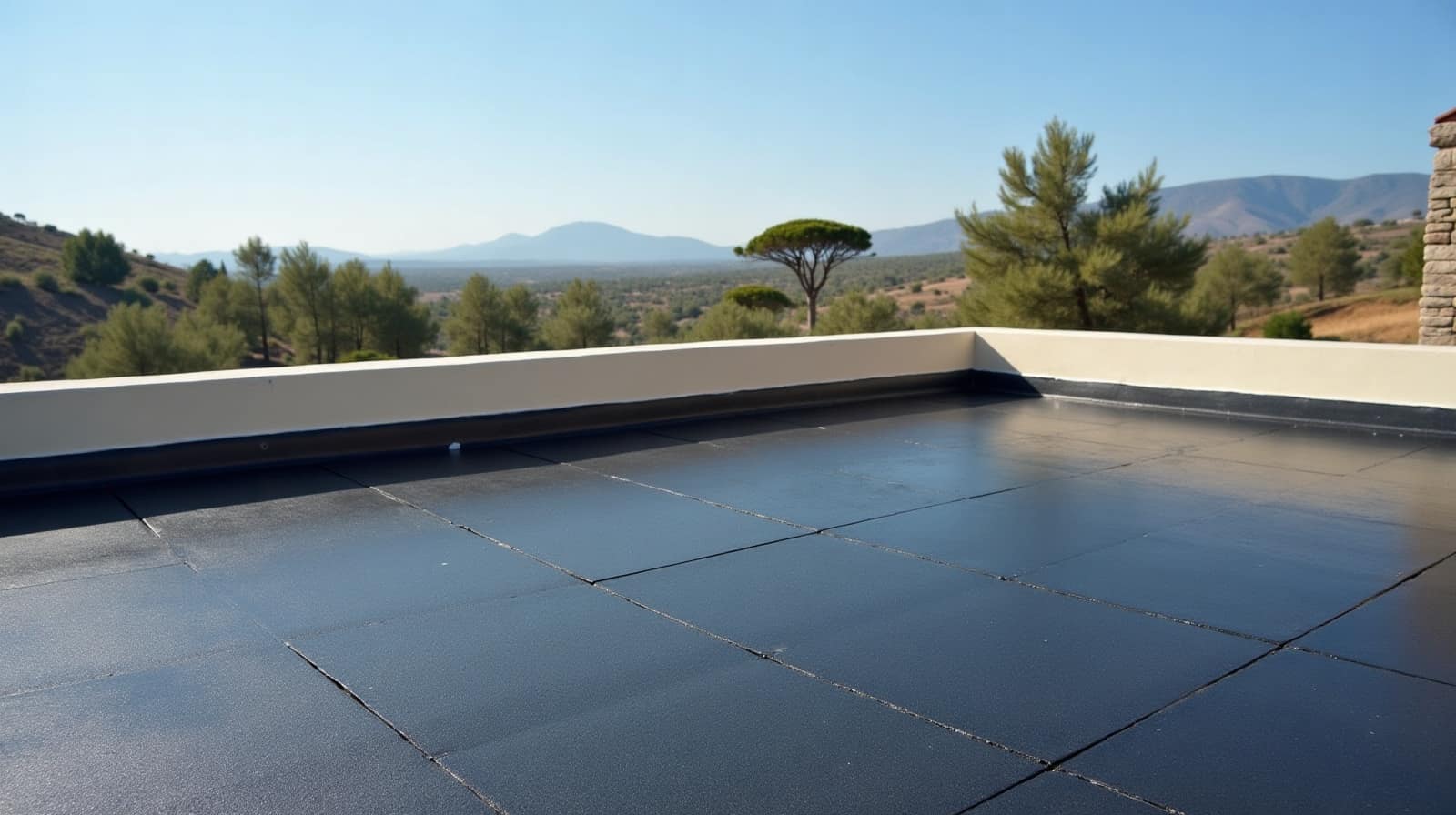 Toiture-terrasse sombre, acrotère blanc, pin parasol et coteaux secs au second plan